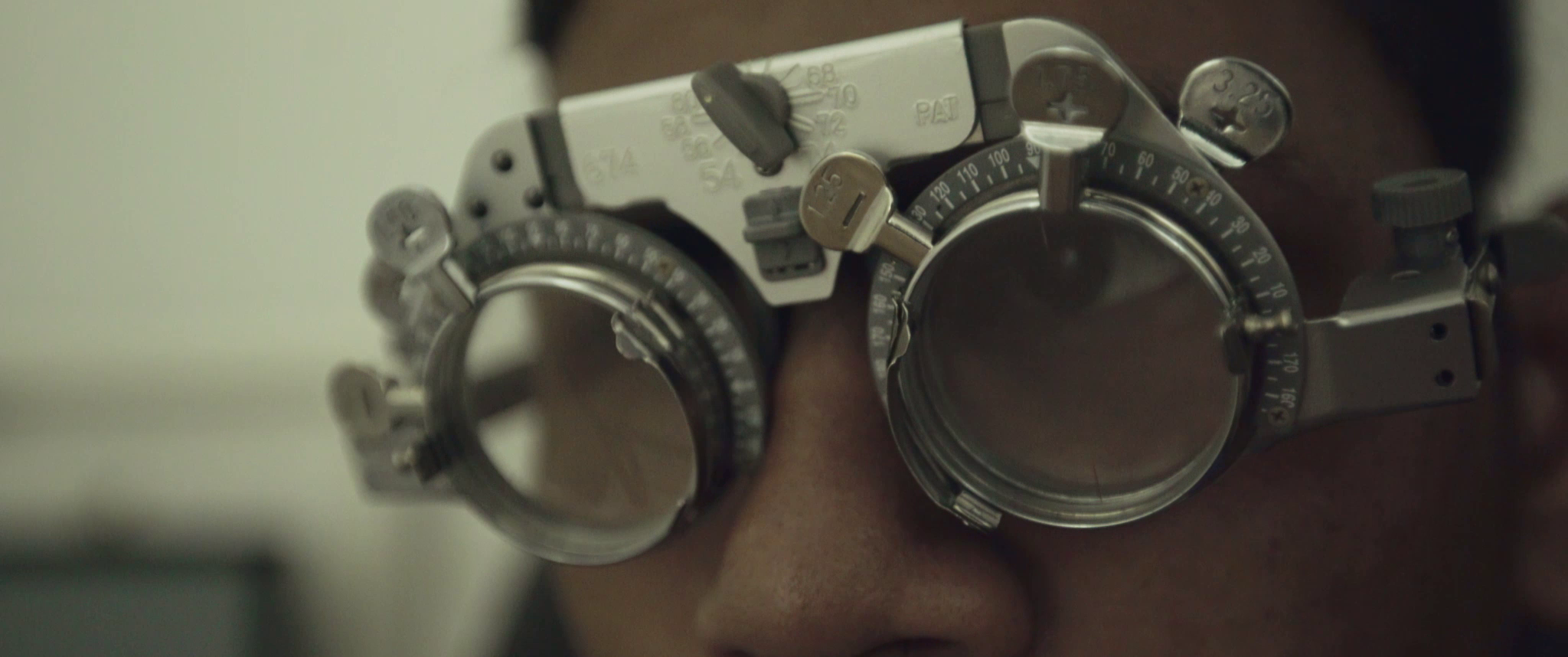 Blind footballer Asri is wearing a testing device with large lenses in a medical examination room.