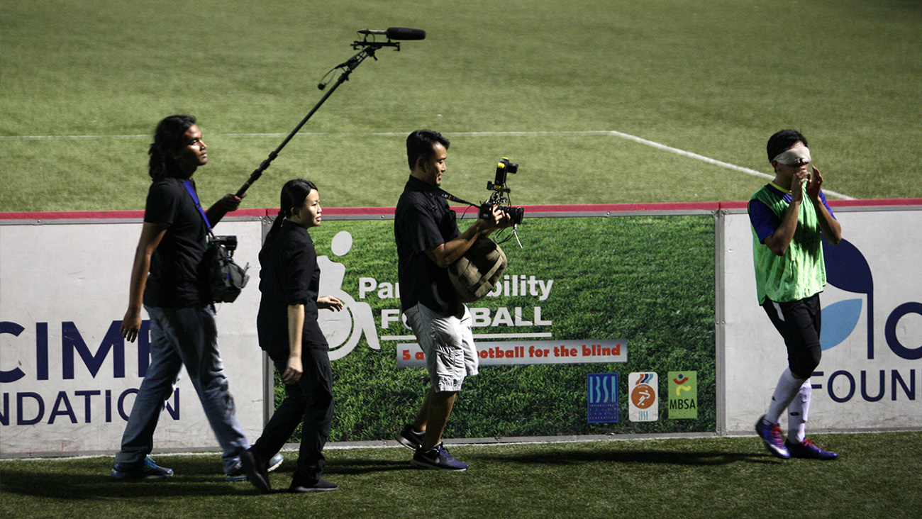 Krew kamera mengekori pemain bola sepak buta Asri di atas padang apabila dia menyeru rakan sepasukannya.