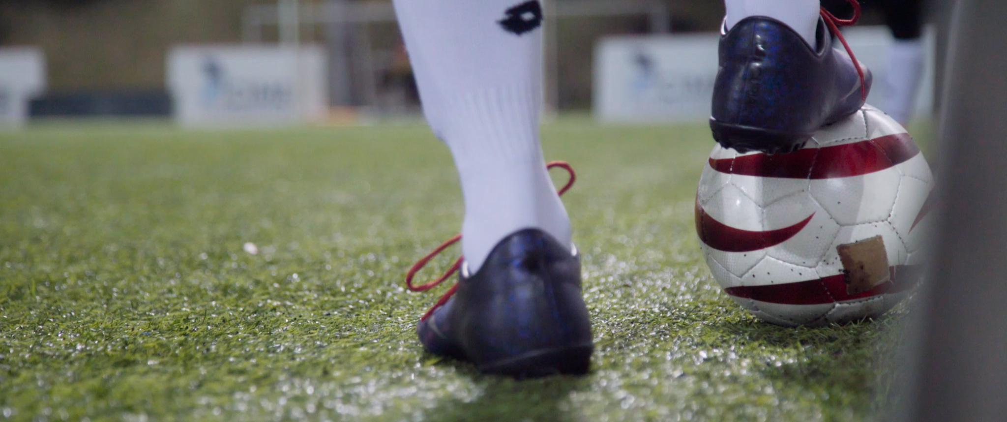 A blind footballer holds the ball with his feet in start position. 